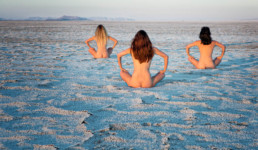 Three Models Sitting on Salt Flats